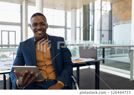 Businessman in suit holding tablet, smiling confidently in modern conference room, copy space Businessman in suit holding tablet, smiling confidently in modern conference room, copy space 126484715