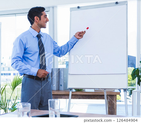 Presenting on whiteboard, business professional leading meeting in modern office Presenting on whiteboard, business professional leading meeting in modern office 126484904