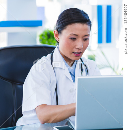 Doctor using laptop in office, focused on medical research and documentation Doctor using laptop in office, focused on medical research and documentation 126484907