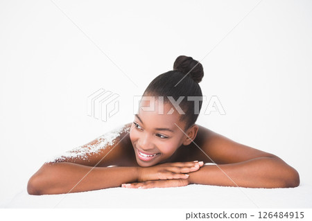 Smiling woman relaxing at spa with exfoliating salt on her back 126484915
