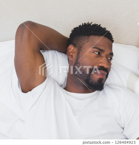 Relaxing in bed, man smiling and enjoying peaceful morning at home 126484923