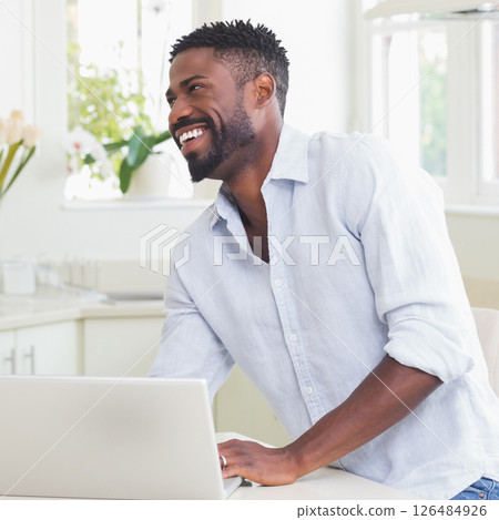 Smiling man using laptop at home, enjoying productive work session Smiling man using laptop at home, enjoying productive work session 126484926