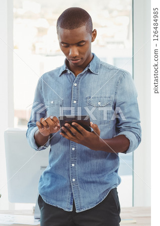 Business professional using tablet in modern office, focusing on digital work 126484985