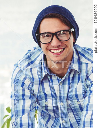 Smiling hipster man wearing glasses and beanie in casual office setting 126484992