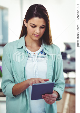 Businesswoman using tablet in modern office, focusing on digital tasks 126484995