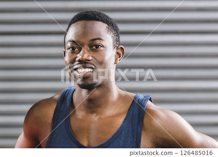 Smiling African American man in gym wearing tank top, feeling confident and strong 126485016