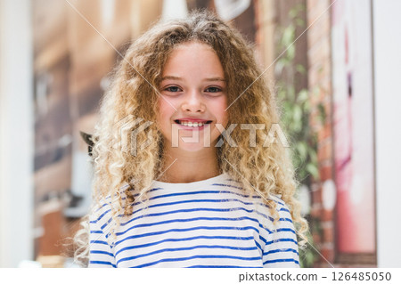 Smiling girl in striped shirt enjoying shopping day at mall 126485050