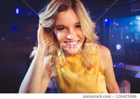 Smiling woman at lively nightclub, dancing and enjoying vibrant nightlife 126485066