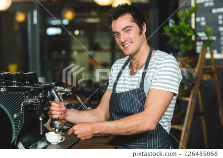 Barista making coffee, smiling while preparing espresso in cozy coffee shop 126485068