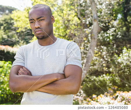 African American man standing outdoors with arms crossed, looking thoughtful 126485080