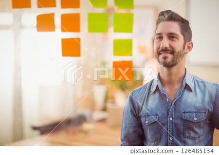 Businessman brainstorming with sticky notes on glass in modern office, copy space 126485134