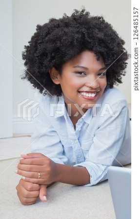 Smiling African American woman relaxing at home, looking cheerful and content Smiling African American woman relaxing at home, looking cheerful and content 126485157