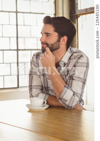 Bearded man in plaid shirt enjoying coffee at trendy cafe 126485180