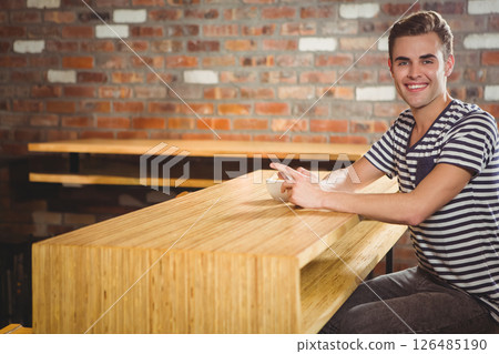Smiling man enjoying coffee at rustic cafe with brick wall background, copy space Smiling man enjoying coffee at rustic cafe with brick wall background, copy space 126485190