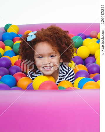 Smiling child playing in colorful ball pit, enjoying fun indoor activity 126485235