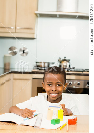 Smiling boy building with blocks at home, enjoying creative playtime, copy space 126485236
