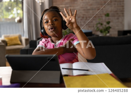 In school, child learning online at home, wearing headphones, raising hand, copy space 126485288