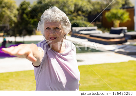 Senior woman practicing yoga outdoors by pool, enjoying sunny day, copy space Senior woman practicing yoga outdoors by pool, enjoying sunny day, copy space 126485293