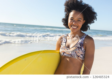 Smiling woman holding surfboard on sunny beach, enjoying summer day, copy space Smiling woman holding surfboard on sunny beach, enjoying summer day, copy space 126485324
