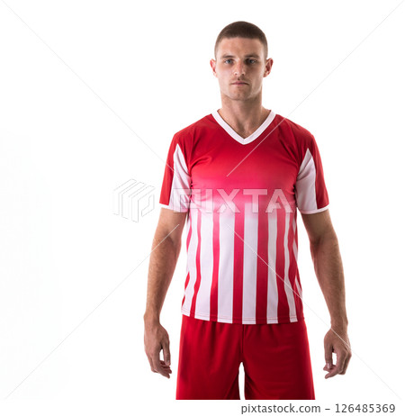 In red and white uniform, male soccer player standing confidently against background, copy space In red and white uniform, male soccer player standing confidently against background, copy space 126485369