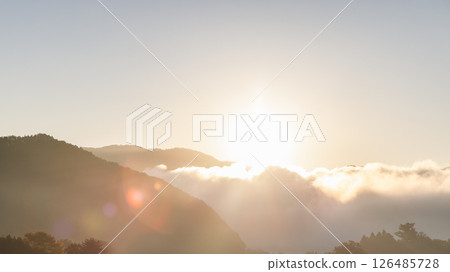 Rays of the rising sun illuminate drifting clouds above the mountains Rays of the rising sun illuminate drifting clouds above the mountains 126485728