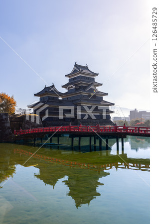 Clear morning reflections of Matsumoto Castle and a traditional red bridge 126485729