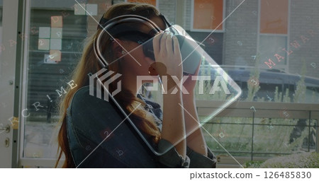 Woman using VR headset at home, exploring virtual reality experience 126485830