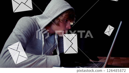 Young man in hoodie using laptop, surrounded by floating email icons 126485872