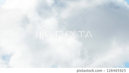 Fluffy white clouds floating in bright blue sky on sunny day 126485925