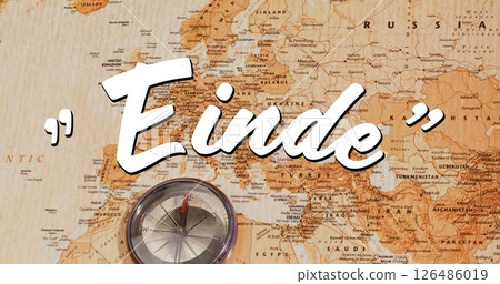 Compass resting on vintage world map with Einde text overlay Compass resting on vintage world map with Einde text overlay 126486019