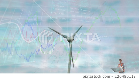 Engineer analyzing wind turbine data with charts overlaying sky background 126486112