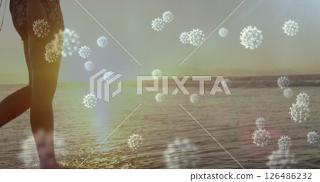 Walking along beach, person with virus illustrations symbolizing pandemic impact 126486232