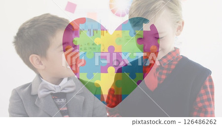Two boys in school smiling and interacting with colorful puzzle heart overlay 126486262