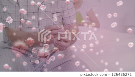 Man in pajamas sitting on bed, surrounded by virus particles, feeling unwell 126486271