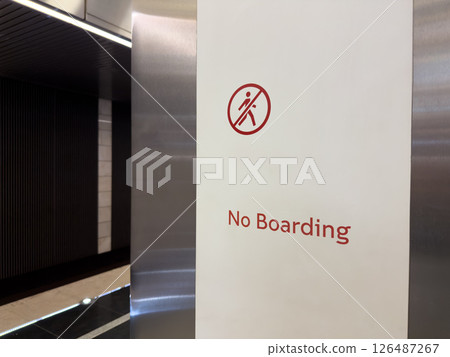 Minimalist No Boarding sign at modern metro station with sleek design elements. Urban safety instruction, public transit infrastructure and prohibition message in clean environment Minimalist No Boarding sign at modern metro station with sleek design elements. Urban safety instruction, public transit infrastructure and prohibition message in clean environment 126487267
