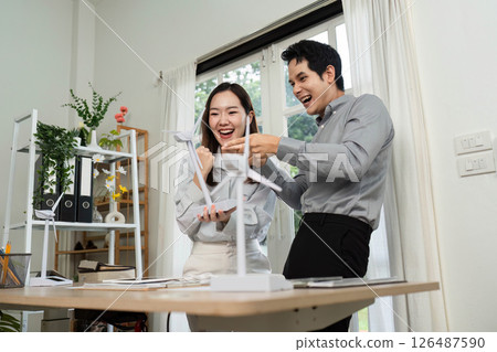 ESG Partnership. Colleagues sharing excitement in a sustainable office environment. 126487590