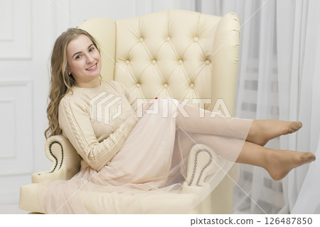 Beautiful blonde in a luxurious armchair. 126487850