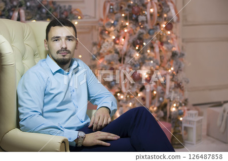 A man in a leather chair on the background of the Christmas tree 126487858