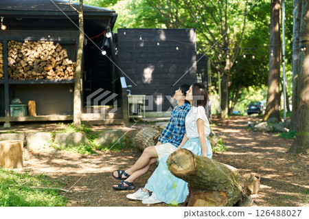 Men and women relaxing while sitting on a fallen tree 126488027