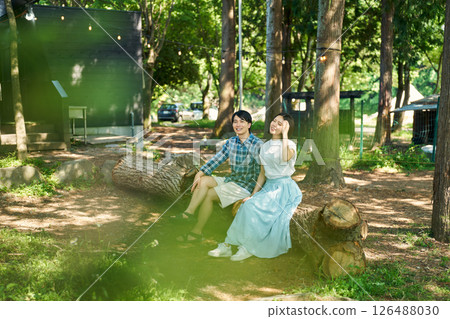 Men and women relaxing while sitting on a fallen tree 126488030