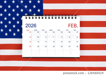 February 2026 desk calendar on United States of America flag. 126488429