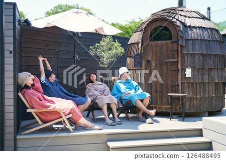 Men and women sitting and cooling off after coming out of the sauna Men and women sitting and cooling off after coming out of the sauna 126488495