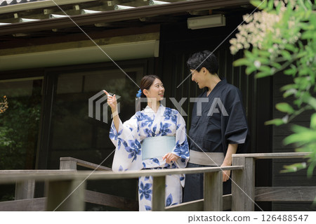一對情侶或已婚夫婦穿著浴衣去溫泉旅行或觀光，指指點點，凝視著，垂直的圖像 126488547