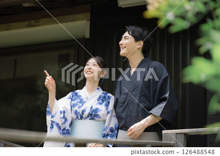 一對情侶或已婚夫婦穿著浴衣去溫泉旅行或觀光，指指點點，凝視著，垂直的圖像 126488548