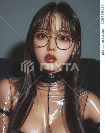 Young woman in stylish glasses poses in a modern setting with a shiny outfit and vibrant makeup Young woman in stylish glasses poses in a modern setting with a shiny outfit and vibrant makeup 126489136