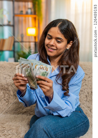 Indian woman counting cash dollars with satisfied smile, feeling financial success and wealth 126489193