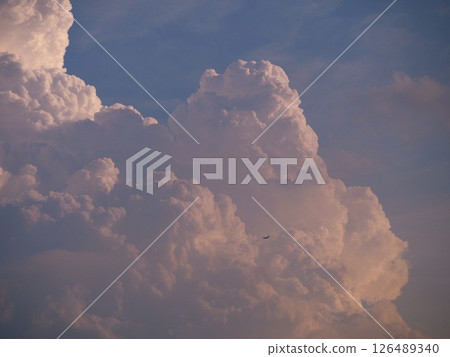 一架客機飛入夏日天空升起的積雨雲 一架客機飛入夏日天空升起的積雨雲 126489340