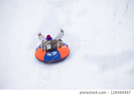 Sledding.Happy child on vacation. Winter fun and games.Little boy enjoying a sleigh ride.Children play outdoors in snow. Kids sled in the Alps mountains in winter Sledding.Happy child on vacation. Winter fun and games.Little boy enjoying a sleigh ride.Children play outdoors in snow. Kids sled in the Alps mountains in winter 126489487
