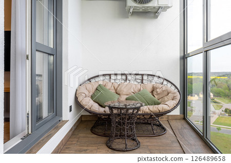 Cozy Balcony Lounge with Rattan Furniture and Scenic View 126489658