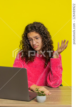 Girl using laptop surprised by bad news, fortune loss, game fail, lottery results sitting at table 126489922